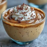 Earthy Hojicha Pudding served chilled in a ramekin, topped with a sprinkle of roasted green tea leaves.