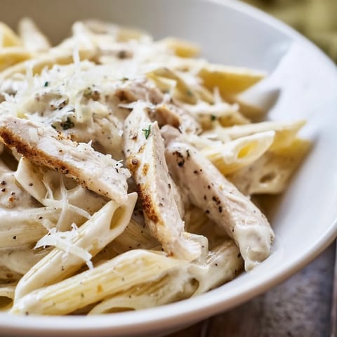 This vibrant Caesar Pasta Chicken Bowl features cherry tomatoes and Parmesan, perfect for a warm or chilled weeknight meal.  