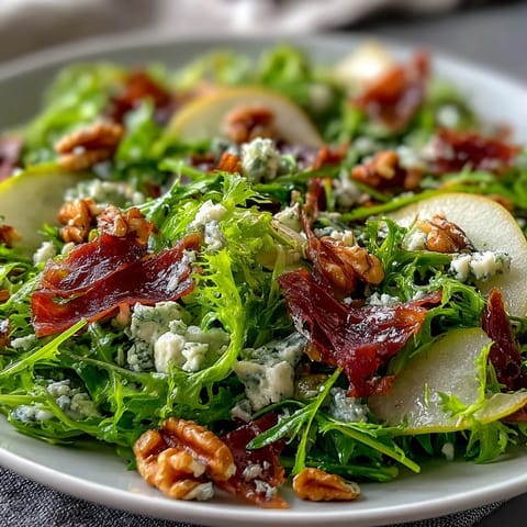 Crispy prosciutto shards and juicy sliced pears top this elegant frisée salad with creamy blue cheese and walnuts.
