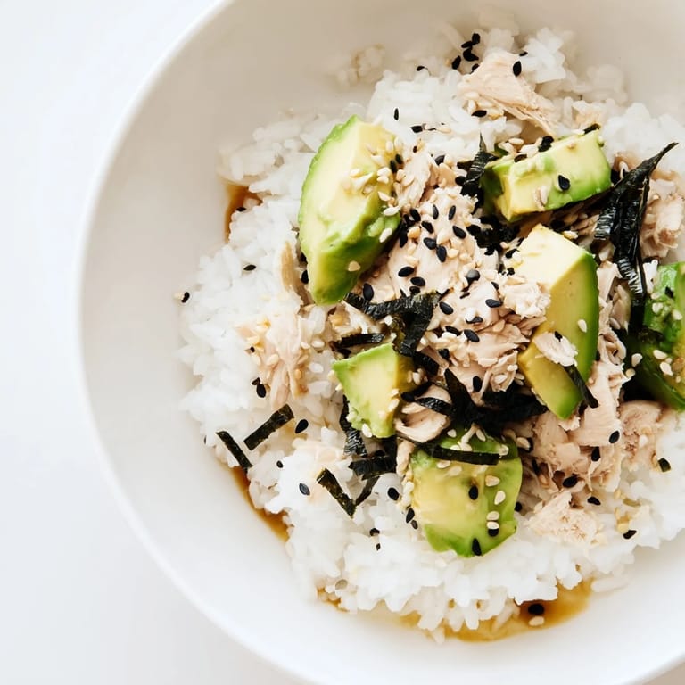 Easy Tuna Avocado Rice Bowl with fragrant jasmine rice, tuna chunks, and fresh veggies, garnished with sesame seeds and optional nori.