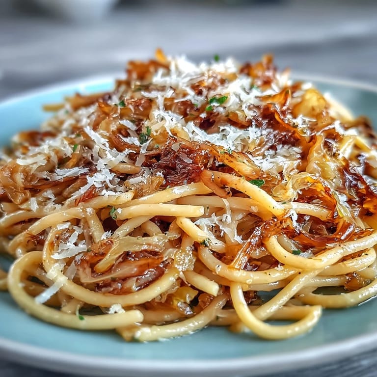 Savory garlic and caramelized cabbage pasta served with lemon zest and fresh parsley garnish.