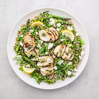 Sliced grilled chicken, tender farro, blanched asparagus, and peas tossed with arugula in a bright lemon vinaigrette for a refreshing warm spring farro chicken salad.  